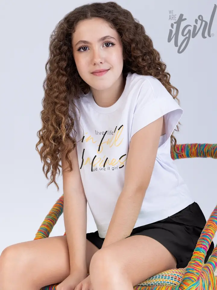 Menina de cabelo cacheado, de camiseta branca